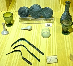 Typical Roman bathing gear included mirrors (the round discs) and strigils (the curved blades -- these are used to scrape off sweat and oil from bathers.)